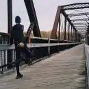 Man Standing on Bridge
