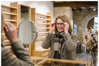 Femme souriante essayant des lunettes dans une boutique élégante