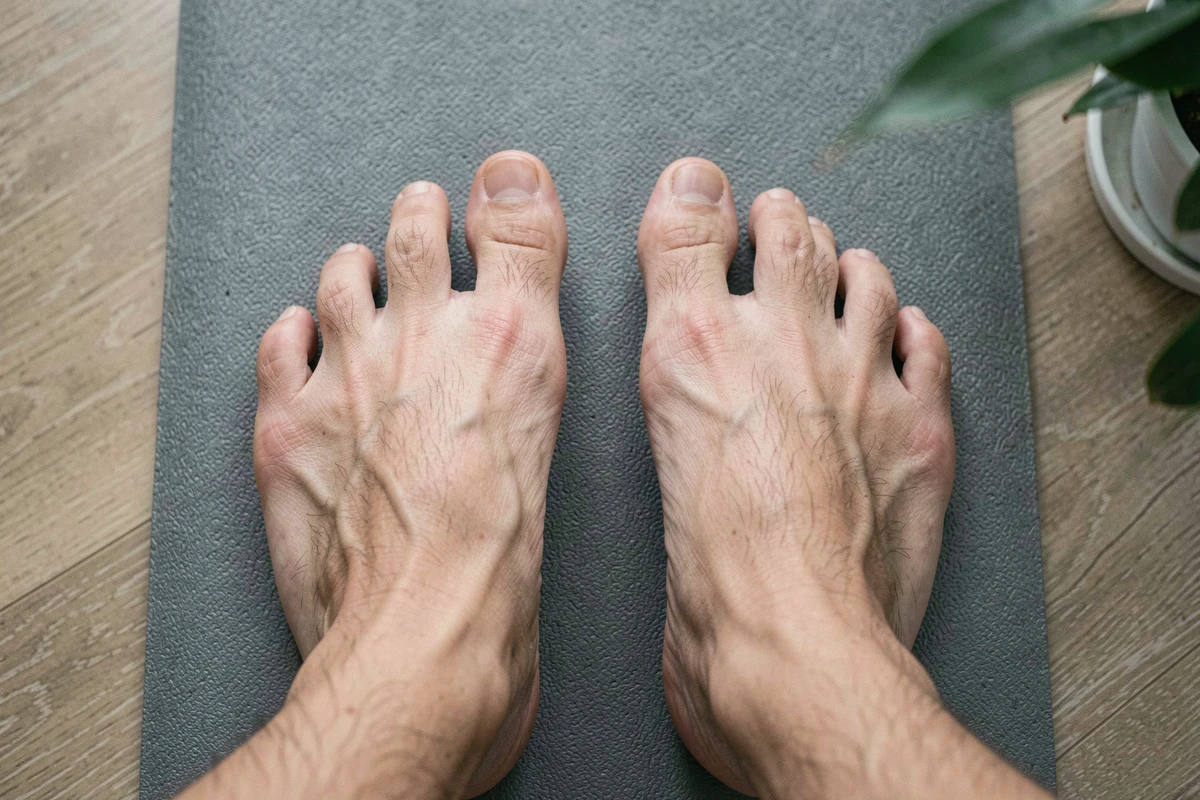 Vue aérienne de pieds nus avec pied égyptien sur tapis d'équilibre, illustrant la morphologie des orteils et les enjeux posturaux