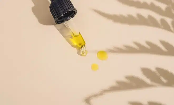 a dropper bottle filled with yellow liquid sitting on top of a table